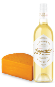 a bottle of Linganore Winecellars White Raven sits next to a Cheddar cheese half wheel