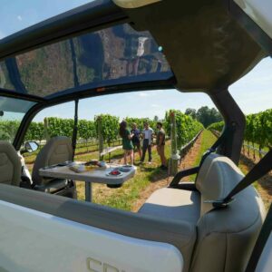 Group touring the vines at Linganore Winecellars seen through the intimate Cru cart they ride on throughout the tour.